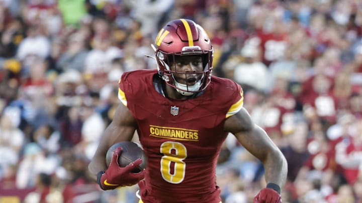 Washington Commanders running back Brian Robinson Jr. carries the ball; Carolina Panthers cornerback Michael Jackson defends Washington Commanders running back Brian Robinson Jr. carries the ball; Carolina Panthers cornerback Michael Jackson defends