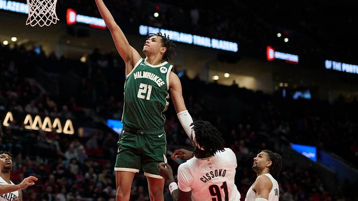 Mar 25, 2026; Portland, Oregon, USA; Milwaukee Bucks forward Ousmane Dieng (21) scores a basket during the second half against Portland Trail Blazers guard Sidy Cissoko (91) at Moda Center. Mandatory Credit: Troy Wayrynen-Imagn Images