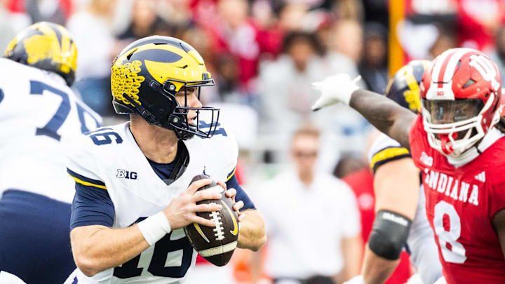 Michigan quarterback Davis Warren (16) looks to throw as Indiana  defensive lineman CJ West (8) closes in Saturday in Bloomington.