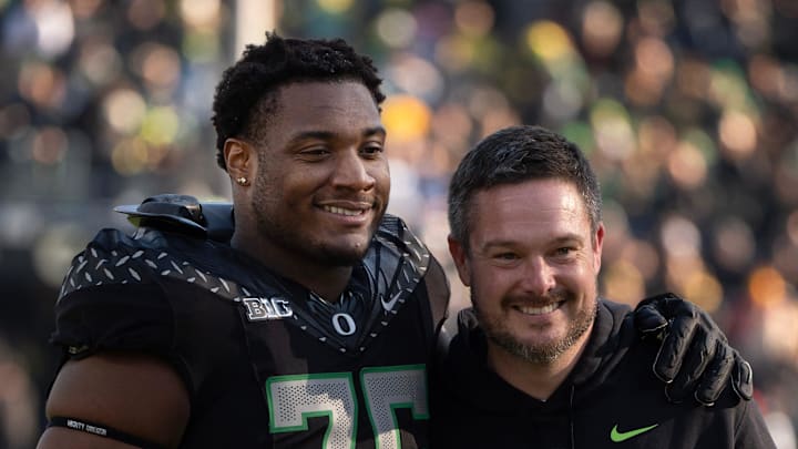 Oregon’s Isaiah World, left, takes a picture with coach Dan Lanning before the game against Southern California Nov. 22, 2025.