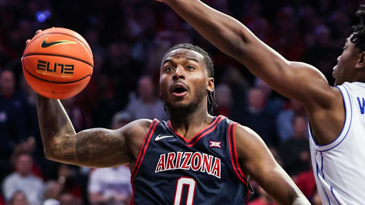 Feb 18, 2026; Tucson, Arizona, USA; Arizona Wildcats guard Jaden Bradley (0) jumps to make a lay up while Brigham Young Cougars guard Robert Wright III (1) fails to block him during the second half of the game at McKale Memorial Center. Mandatory Credit: Aryanna Frank-Imagn Images
