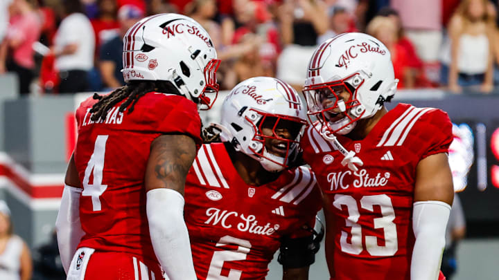 Aug 28, 2025; Raleigh, North Carolina, USA; North Carolina State Wolfpack safety Ronnie Royal III (2),  linebacker Tra Thomas (4) and  linebacker Kenny Soares Jr. (33) celebrate during the first half of the game against East Carolina Pirates at Carter-Finley Stadium. Mandatory Credit: Jaylynn Nash-Imagn Images