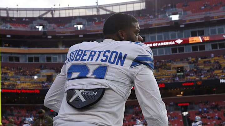 Nov 9, 2025; Landover, Maryland, USA; Detroit Lions cornerback Amik Robertson (21) kneels on the field during warmups prior to a game against the Washington Commanders at Northwest Stadium. Mandatory Credit: Peter Casey-Imagn Images