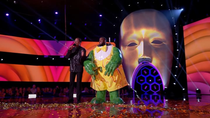 Host Nick Cannon stands with Kobie Turner during a big reveal on Fox's "The Masked Singer" on Dec. 4, 2024.