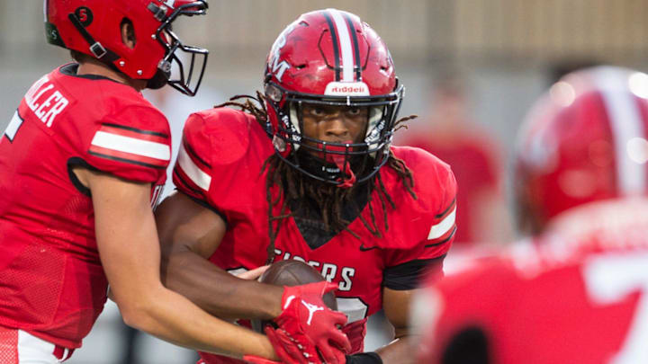 T.R. Miller's Nathan Commander (5) hands the ball off to Myles Johnson (32) during the AHSAA Kickoff game at Cramton Bowl in Montgomery, Ala., on Thursday, Aug. 22, 2024. T.R. Miller and Reeltown are tied 7-7 at halftime.