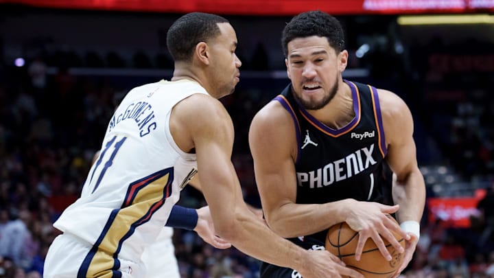 Dec 26, 2025; New Orleans, Louisiana, USA; Phoenix Suns guard Devin Booker (1) tries to dribble around New Orleans Pelicans guard Bryce McGowens (11) during the first half at Smoothie King Center. Mandatory Credit: Matthew Hinton-Imagn Images