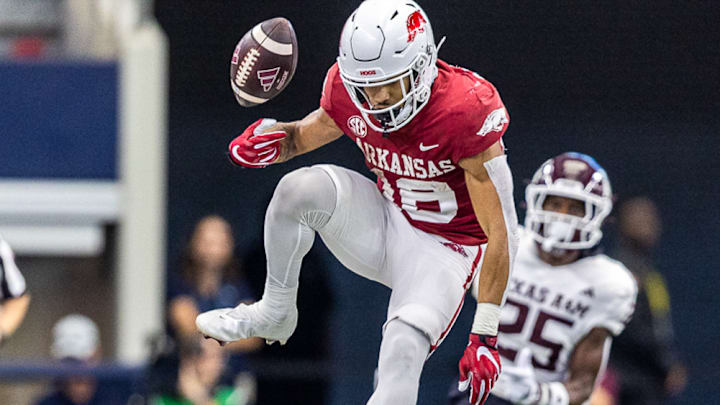 Arkansas Razorbacks returner Isaiah Sategna tries to jump a Texas A&M Aggies defender and loses ball in September 2023 at AT&T Stadium in Arlington, Texas.