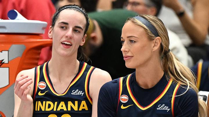 Indiana Fever guards Caitlin Clark and Sophie Cunningham talk on the bench.