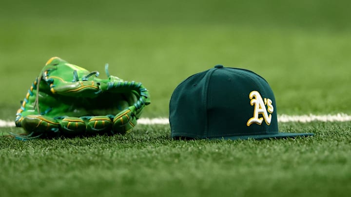 Jul 22, 2025; Arlington, Texas, USA;  Athletics glove and hat on the field before the game against the Texas Rangers at Globe Life Field. Mandatory Credit: Kevin Jairaj-Imagn Images