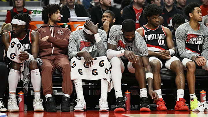 Mar 11, 2024; Portland, Oregon, USA; The Portland Trail Blazers bench, from left, guard Malcolm Brogdon (11), guard Shaedon Sharpe (17), center Duop Reath (26), center Deandre Ayton (2), guard Scoot Henderson (00), and guard Anfernee Simons (1) watch the final minutes of a game against the Boston Celtics at Moda Center. Mandatory Credit: Troy Wayrynen-Imagn Images