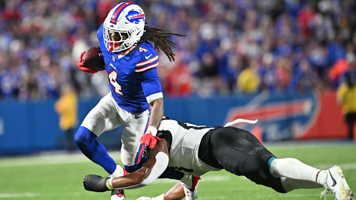 Buffalo Bills running back James Cook is tackled by Jacksonville Jaguars linebacker Ventrell Miller.