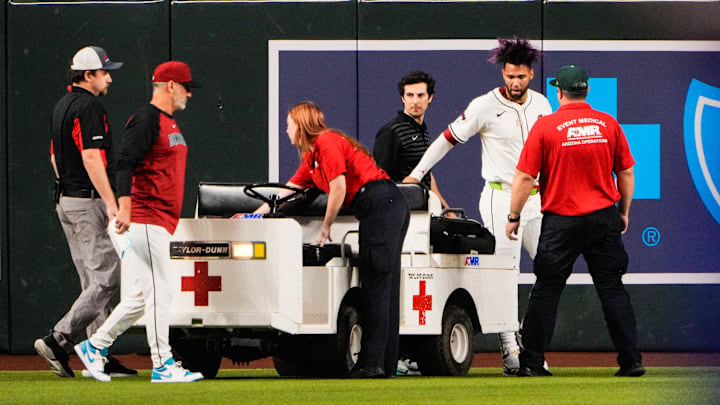Sep 1, 2025; Phoenix, Arizona, USA; Arizona Diamondbacks outfielder Lourdes Gurriel Jr. (12) is loaded on a cart after colliding with Arizona Diamondbacks centerfielder Blaze Alexander (9) in the outfield in the sixth inning during the game between the Texas Rangers and Arizona Diamondbacks at Chase Field. Mandatory Credit: Arianna Grainey-Imagn Images