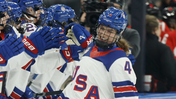 Feb 10, 2026; Milan, Italy; Caroline Harvey (4) of the United States celebrates with teammates after scoring a goal against Canada in women's ice hockey group A play during the Milano Cortina 2026 Olympic Winter Games at Milano Santagiulia Ice Hockey Arena. Mandatory Credit: Geoff Burke-Imagn Images