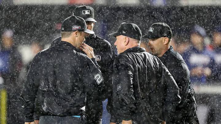Aug 2, 2025; Bristol, Tennessee, USA; The umpires speak as rain falls during the first inning of the Speedway Classic game between the Cincinnati Reds and the Atlanta Braves at Bristol Motor Speedway. Mandatory Credit: Randy Sartin-Imagn Images