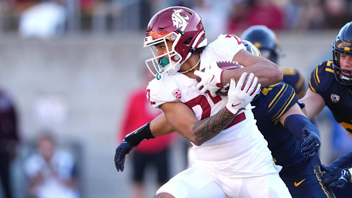 Nov 11, 2023; Berkeley, California, USA; Washington State Cougars running back Leo Pulalasi (22) carries the ball against California Golden Bears linebackers Nate Rutchena (obscured) and Cade Uluave (27) during the third quarter at California Memorial Stadium. Mandatory Credit: Darren Yamashita-Imagn Images