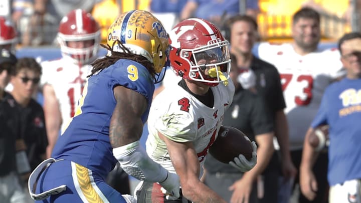 Sep 21, 2024; Pittsburgh, Pennsylvania, USA;  Youngstown State Penguins wide receiver Max Tomczak (4) runs after a catch against Pittsburgh Panthers linebacker Kyle Louis (9) during the second quarter  at Acrisure Stadium. Mandatory Credit: Charles LeClaire-Imagn Images