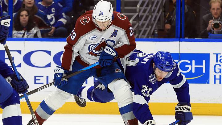 Jan 6, 2026; Tampa, Florida, USA; Colorado Avalanche center Nathan MacKinnon (29) skates with the puck as Tampa Bay Lightning center Brayden Point (21) attempted to defend during the second period at Benchmark International Arena. Mandatory Credit: Kim Klement Neitzel-Imagn Images