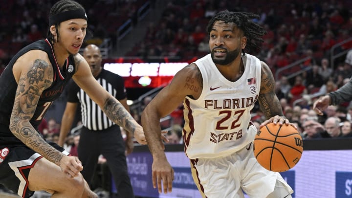 Feb 3, 2024; Louisville, Kentucky, USA; Florida State Seminoles guard Darin Green Jr. (22) dribbles against Louisville Cardinals guard Tre White (22) during the first half at KFC Yum! Center. Mandatory Credit: Jamie Rhodes-USA TODAY Sports