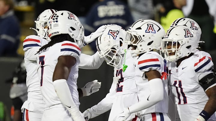 Nov 1, 2025; Boulder, Colorado, USA; Arizona Wildcats defensive back Genesis Smith (12) (center) celebrates his interception with teammates in the second half against the Colorado Buffaloes at Folsom Field. Mandatory Credit: Ron Chenoy-Imagn Images