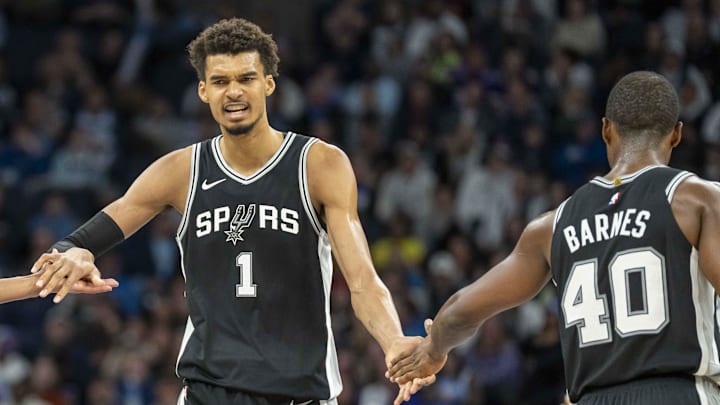 Dec 29, 2024; Minneapolis, Minnesota, USA; San Antonio Spurs center Victor Wembanyama (1) celebrates with San Antonio Spurs guard Devin Vassell (24) and San Antonio Spurs forward Harrison Barnes (40) after making a shot against the Minnesota Timberwolves in the second half at Target Center.