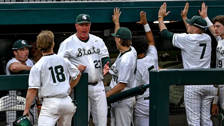 Michigan State's Noah Bright, left, celebrates his score with head coach Jake Boss Jr., center, and the dugout during the eighth inning in the game against Ohio State on Friday, April 18, 2025, at McLane Stadium in East Lansing. Michigan State's Noah Bright, left, celebrates his score with head coach Jake Boss Jr., center, and the dugout during the eighth inning in the game against Ohio State on Friday, April 18, 2025, at McLane Stadium in East Lansing.
