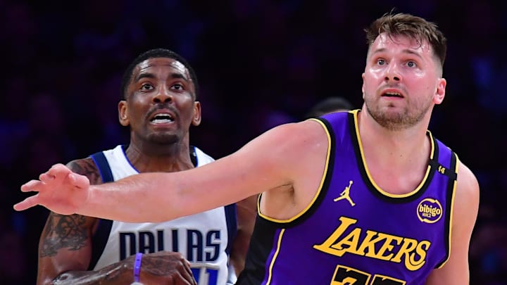 Feb 25, 2025; Los Angeles, California, USA; Los Angeles Lakers guard Luka Doncic (77) and Dallas Mavericks guard Kyrie Irving (11) attempt to gain control during the first quarter at Crypto.com Arena. Mandatory Credit: Gary A. Vasquez-Imagn Images