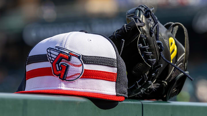 Jul 8, 2024; Detroit, Michigan, USA; A Cleveland Guardians baseball cap and glove sit on the dugout rail before the game against the Detroit Tigers at Comerica Park. Mandatory Credit: David Reginek-Imagn Images