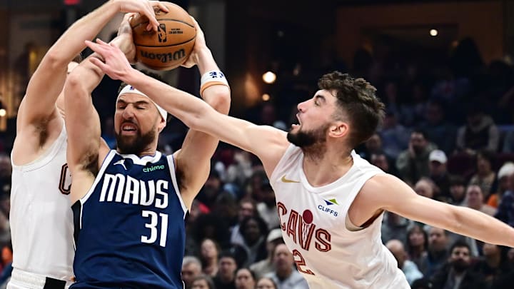 Feb 2, 2025; Cleveland, Ohio, USA; Dallas Mavericks guard Klay Thompson (31) tries to control the ball against Cleveland Cavaliers guard Sam Merrill (5) and guard Ty Jerome (2) during the first half at Rocket Mortgage FieldHouse. Mandatory Credit: Ken Blaze-Imagn Images