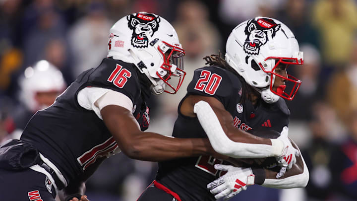 Nov 21, 2024; Atlanta, Georgia, USA; North Carolina State Wolfpack quarterback CJ Bailey (16) hands the ball off to running back Hollywood Smothers (20) Georgia Tech Yellow Jackets in the first quarter at Bobby Dodd Stadium at Hyundai Field. Mandatory Credit: Brett Davis-Imagn Images