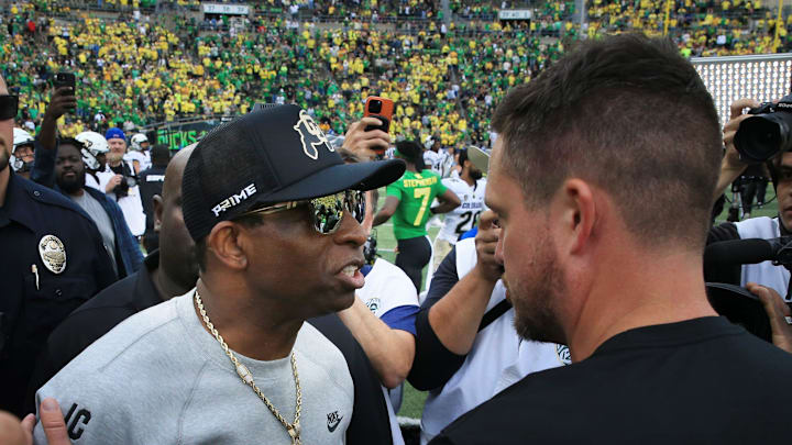 Colorado coach Deion Sanders, left, and Oregon's Dan Lanning meet at midfield after the game at Autzen Stadium.