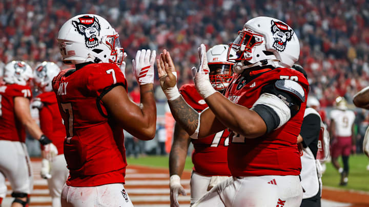 Nov 21, 2025; Raleigh, North Carolina, USA;  NC State Wolfpack tight end Justin Joly (7) celebrates his touchdown with offensive lineman Michael Gibbs (76) to win the game during the second half of the game against Florida State Seminoles at Carter-Finley Stadium. Mandatory Credit: Jaylynn Nash-Imagn Images