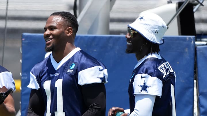 Dallas Cowboys stars Micah Parsons and DeMarvion Overshown laugh on the sideline during training camp in Oxnard, California. 