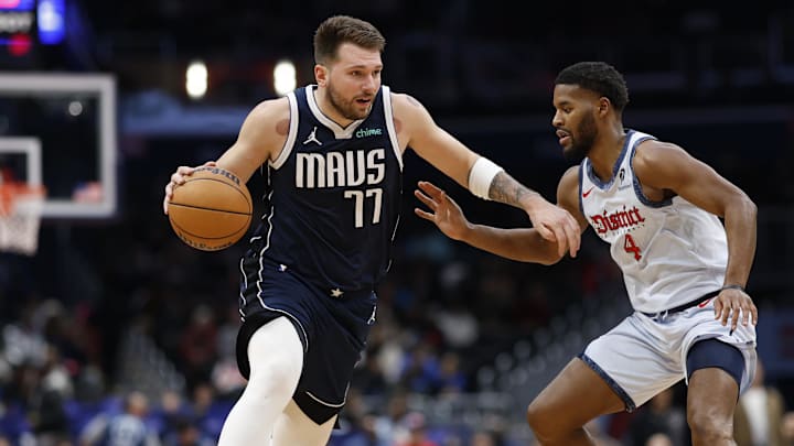 Dec 5, 2024; Washington, District of Columbia, USA; Dallas Mavericks guard Luka Doncic (77) drives to the basket as Washington Wizards guard Jared Butler (4) defends in the second quarter at Capital One Arena. Mandatory Credit: Geoff Burke-Imagn Images