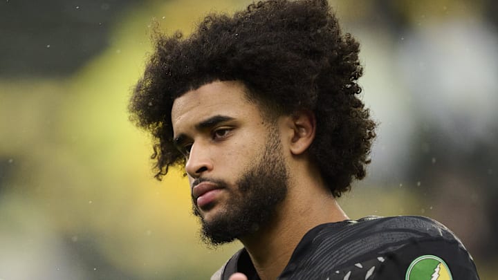 Oct 25, 2025; Eugene, Oregon, USA; Oregon Ducks quarterback Dante Moore (5) talks to officials during warm-ups before a game against the Wisconsin Badgers at Autzen Stadium. The Ducks are wearing uniforms celebrating the Grateful Dead. Mandatory Credit: Troy Wayrynen-Imagn Images
