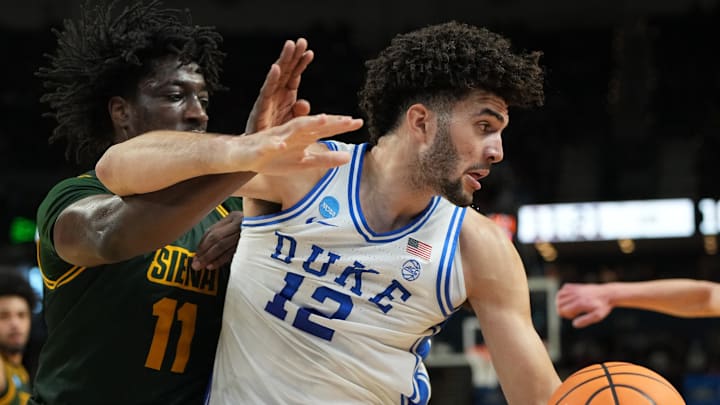 Mar 19, 2026; Greenville, SC, USA; Duke Blue Devils forward Cameron Boozer (12) grabs a rebound against Siena Saints forward Francis Folefac (11) in the first half during a first round game of the men's 2026 NCAA Tournament at Bon Secours Wellness Arena. Mandatory Credit: Bob Donnan-Imagn Images