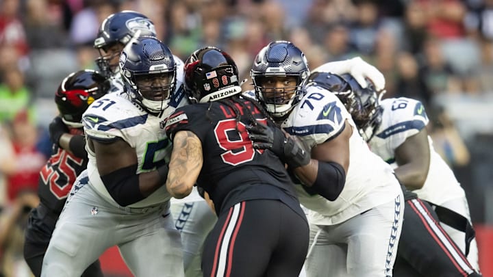 Dec 8, 2024; Glendale, Arizona, USA; Seattle Seahawks center Olu Oluwatimi (51) and guard Laken Tomlinson (70) against Arizona Cardinals defensive tackle Roy Lopez (98) at State Farm Stadium. Mandatory Credit: Mark J. Rebilas-Imagn Images