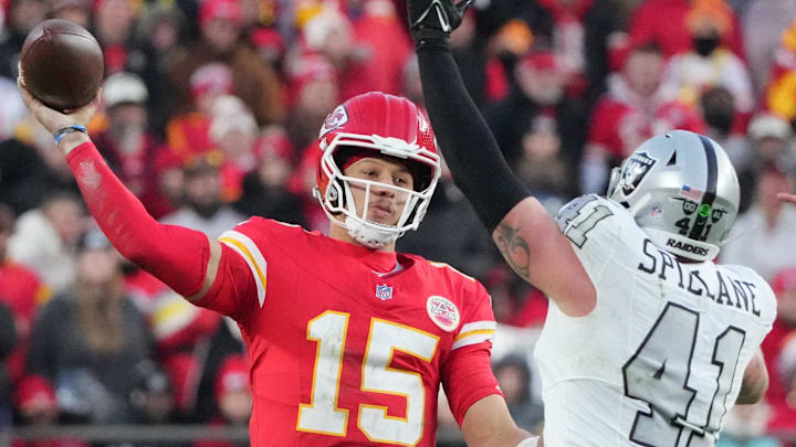 Nov 29, 2024; Kansas City, Missouri, USA; Kansas City Chiefs quarterback Patrick Mahomes (15) throws a pass as Las Vegas Raiders linebacker Robert Spillane (41) defends  during the second half at GEHA Field at Arrowhead Stadium. Mandatory Credit: Denny Medley-Imagn Images