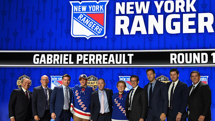 Jun 28, 2023; Nashville, Tennessee, USA; New York Rangers draft pick Gabriel Perreault stands with Rangers staff after being selected with the twenty third pick in round one of the 2023 NHL Draft at Bridgestone Arena. Mandatory Credit: Christopher Hanewinckel-Imagn Images