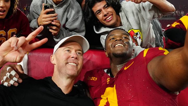 Nov 29, 2025; Los Angeles, California, USA; Southern California Trojans head coach Lincoln Riley (right) and defensive tackle Jahkeem Stewart (4) pose with fans after the game against the UCLA Bruins at United Airlines Field at Los Angeles Memorial Coliseum. Nov 29, 2025; Los Angeles, California, USA; Southern California Trojans head coach Lincoln Riley (right) and defensive tackle Jahkeem Stewart (4) pose with fans after the game against the UCLA Bruins at United Airlines Field at Los Angeles Memorial Coliseum.