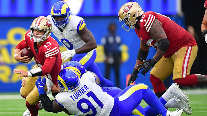 Sep 22, 2024; Inglewood, California, USA; San Francisco 49ers quarterback Brock Purdy (13) is brought down by Los Angeles Rams defensive tackle Braden Fiske (55) and defensive tackle Kobie Turner (91) during the second half at SoFi Stadium. Mandatory Credit: Gary A. Vasquez-Imagn Images Sep 22, 2024; Inglewood, California, USA; San Francisco 49ers quarterback Brock Purdy (13) is brought down by Los Angeles Rams defensive tackle Braden Fiske (55) and defensive tackle Kobie Turner (91) during the second half at SoFi Stadium. Mandatory Credit: Gary A. Vasquez-Imagn Images