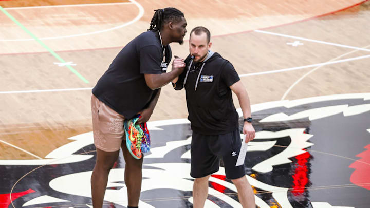 NC State assistant coach Brandon Chambers greets former player DJ Burns during a practice in Raleigh. NC State assistant coach Brandon Chambers greets former player DJ Burns during a practice in Raleigh.