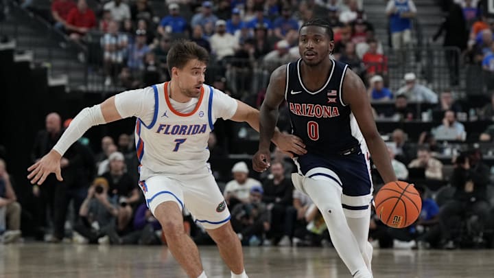 Nov 3, 2025; Las Vegas, NV, USA; Arizona Wildcats guard Jaden Bradley (0) dribbles against Florida Gators guard Urban Klavzar (7) during the second half of the Hall of Fame Series game at T-Mobile Arena. Mandatory Credit: Candice Ward-Imagn Images