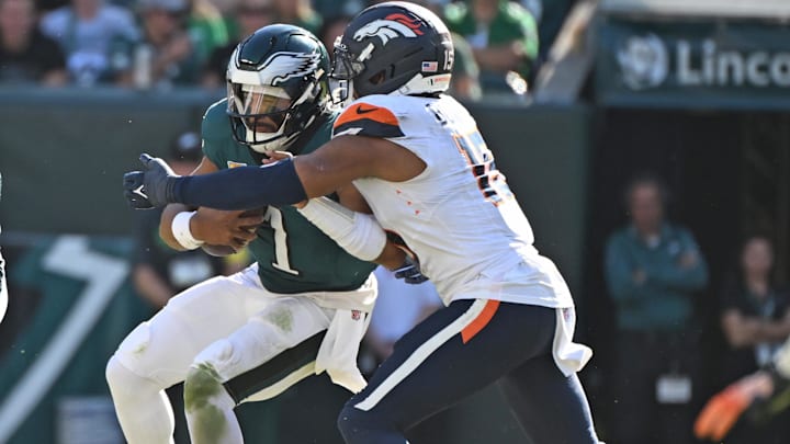 Oct 5, 2025; Philadelphia, Pennsylvania, USA; Philadelphia Eagles quarterback Jalen Hurts (1) is sacked by Denver Broncos linebacker Nik Bonitto (15) at Lincoln Financial Field. 