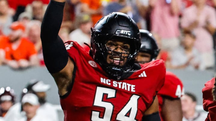 Sep 27, 2025; Raleigh, North Carolina, USA;  North Carolina State Wolfpack defensive end Sabastian Harsh (54) and North Carolina State Wolfpack cornerback Jamel Johnson (21) celebrate during the first half of the game against Virginia Tech Hokies at Carter-Finley Stadium. Mandatory Credit: Jaylynn Nash-Imagn Images