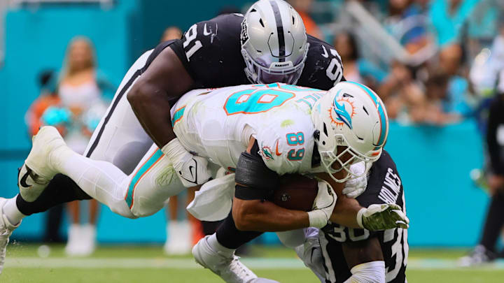 Nov 17, 2024; Miami Gardens, Florida, USA; Miami Dolphins tight end Julian Hill (89) runs with the football against Las Vegas Raiders cornerback Darnay Holmes (30) and defensive tackle Matthew Butler (91) during the third quarter at Hard Rock Stadium. Mandatory Credit: Sam Navarro-Imagn Images