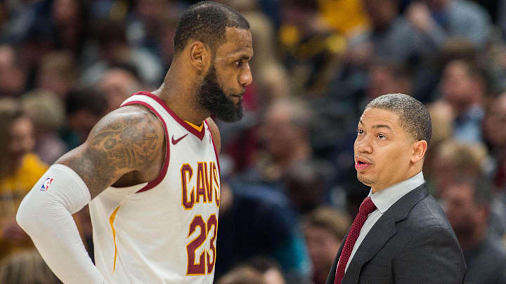 Former Cleveland Cavaliers forward LeBron James and coach Tyronn Lue talk during a game in 2018.