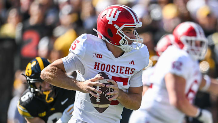 Sep 27, 2025; Iowa City, Iowa, USA; Indiana Hoosiers quarterback Fernando Mendoza (15) rolls out to throw a pass against the Iowa Hawkeyes during the first quarter at Kinnick Stadium. Mandatory Credit: Jeffrey Becker-Imagn Images