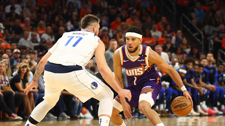 Oct 26, 2024; Phoenix, Arizona, USA; Phoenix Suns guard Devin Booker (1) against Dallas Mavericks guard Luka Doncic (77) in the first half of the home opener at Footprint Center. Mandatory Credit: Mark J. Rebilas-Imagn Images