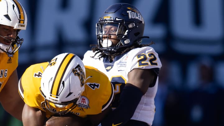 Toledo Rockets safety Emmanuel McNeil-Warren (22) tackles Wyoming Cowboys running back Harrison Waylee (4) in the Arizona Bowl at Arizona Stadium.