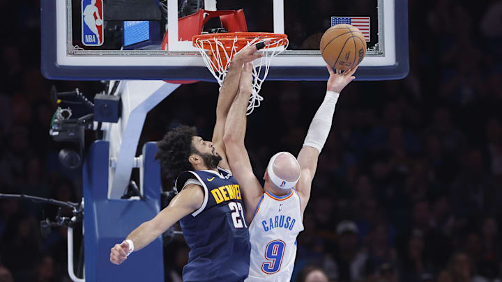 Mar 10, 2025; Oklahoma City, Oklahoma, USA; Oklahoma City Thunder guard Alex Caruso (9) shoots as Denver Nuggets guard Jamal Murray (27) defends during the second quarter at Paycom Center. Mandatory Credit: Alonzo Adams-Imagn Images